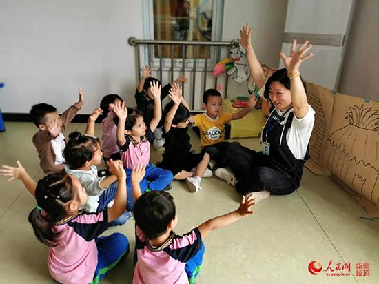 圖為北京援疆教師劉愛華為幼兒示范動作。