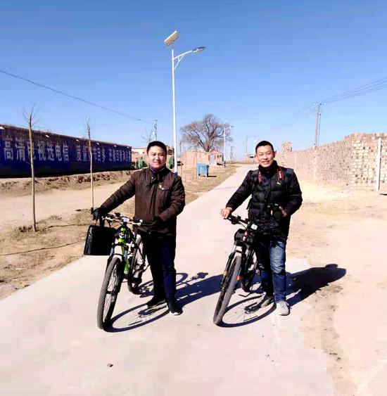张华（左）正在走访入户的路上。