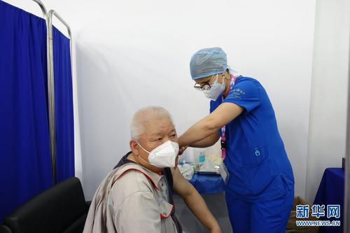     4月14日，在突尼斯首都突尼斯市，工作人员为一名准备接种新冠疫苗的中国公民检查体温。新华社发