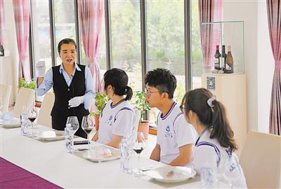 <p>　　　　刘莉（左一）向访客介绍专业的葡萄酒知识。</p>