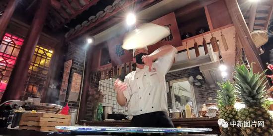 2021年10月23日，江苏苏州一家特色餐厅的厨师在制作抛饼。 李舸  摄