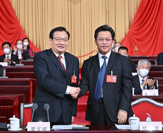 新当选的自治区人大常委会主任梁言顺与新当选的自治区人民政府主席张雨浦亲切握手。