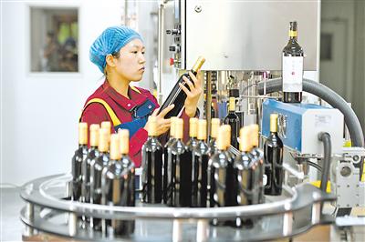     工人检查包装好的葡萄酒。