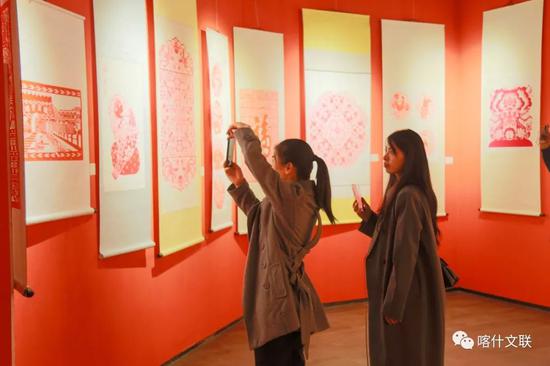 “丝路风情 艺结同心——山东·喀什美术书法摄影民艺作品联展”活动中，前来打卡留念的群众。供图：李石磊