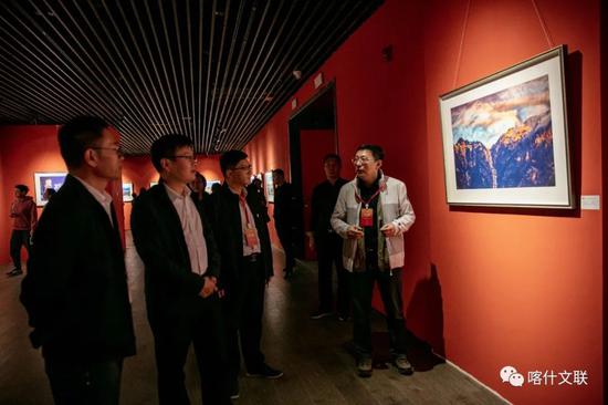      “ 丝路风情 艺结同心——山东·喀什美术书法摄影民艺作品联展”活动中，山东省文联艺术家向大家介绍摄影作品。供图：高嵩