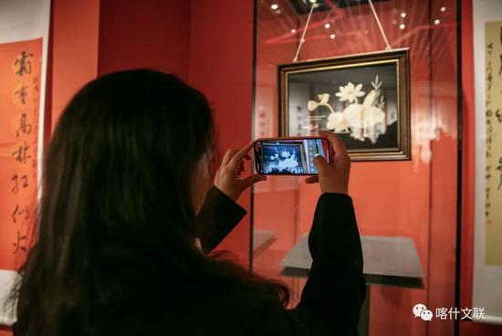 “丝路风情 艺结同心——山东·喀什美术书法摄影民艺作品联展”活动中，前来打卡留念的群众。供图：高嵩
