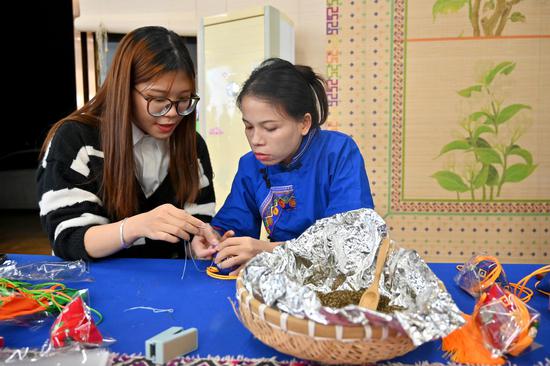 11月19日，游客在广西横州茉莉花“1+9”体验区内体验制作茉莉花香囊。 俞靖 摄