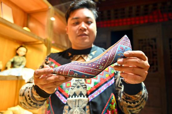 11月23日，兰培文在展示融合了壮锦的高跟鞋。俞靖 摄