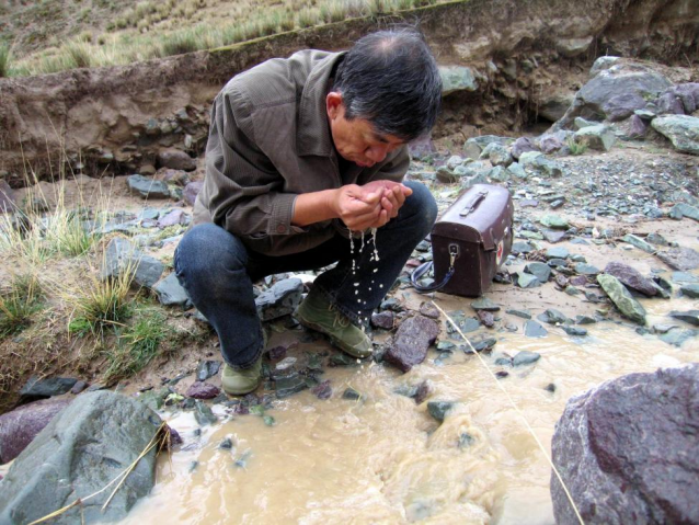 2007年6月19日中午，姜万富在新疆叶城二牧场，喝浑浊的渠水。