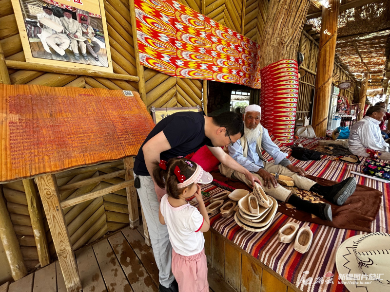 5月3日，来自阿克苏的小游客爱丽丝·依斯热比力在观看卡盆制作。 石榴云/新疆日报记者 张小宓摄