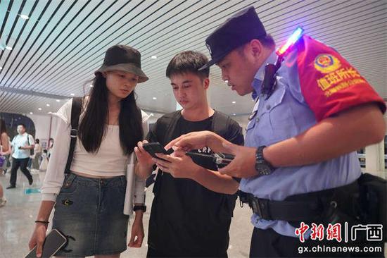 图为民警在指导旅客出行。王昌昱摄