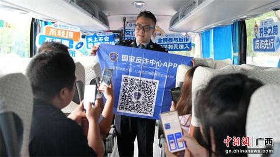 图为“警营魔术师”在大巴车上开设“反诈防诈·你我同行”流动讲堂,向新生和家长宣传反诈知识。