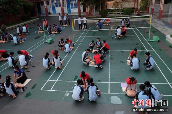 图为师生们在志愿者的指导下进行心肺复苏术实操演练。李永富 摄