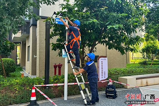 图为电信工作人员在检查监控摄像头。汤细藜 摄