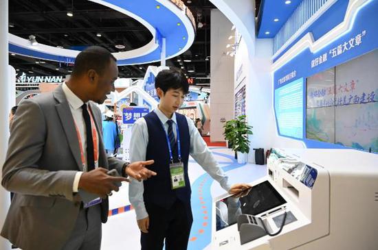 北行工作人员正在为国际友人介绍北行新版智能柜台,为其现场办理储蓄卡业务