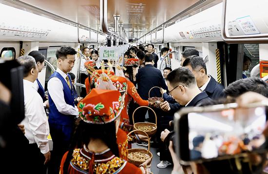 　9月30日，“魅力兵團  豫見新星”河南援疆鄭州地鐵“新星號”專列發(fā)車儀式在鄭州地鐵1號線紫荊山站舉行。圖為十三師新星市工作人員向地鐵乘客推介新疆干果。