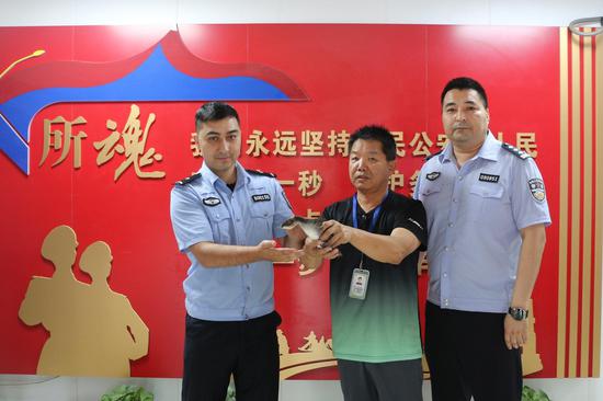 克拉玛依市公安局白碱滩区分局三环路派出民警将䴙䴘交给白碱滩区林业和草原有害生物防治检疫站工作人员。孙宝莉 摄