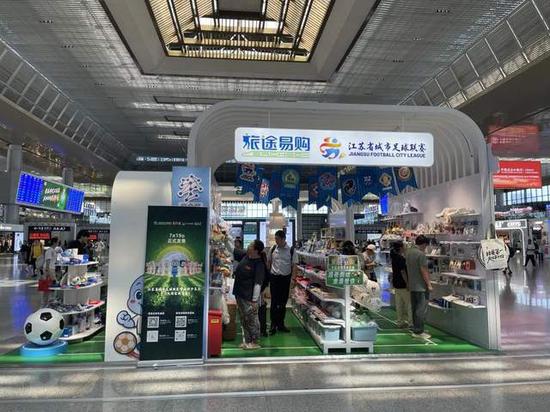 8月18日，南京南站“苏超”文创商店，旅客在挑选苏超周边文创产品。国是直通车 段修健 摄