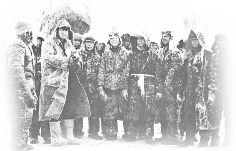 1956年2月，克拉玛依油田员工在制服了黑油山2号井的井喷后合影。严寒中，他们的衣服、帽子都被打湿冻成了冰盔冰甲，身后的井架也成了冰塔。