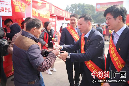 邮储银行梧州市分行行长覃延宁为返乡务工人员送上热姜茶。 邮储银行梧州市分行行长覃延宁为返乡务工人员送上热姜茶。