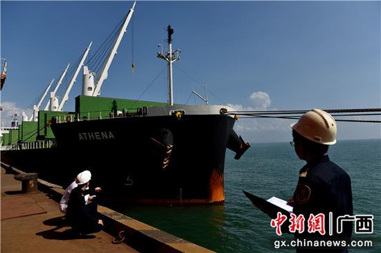 北海海关关员对载重大豆进口的船舶进行水尺计重,读取船舶水尺标志数。包拥军 摄 北海海关关员对载重大豆进口的船舶进行水尺计重,读取船舶水尺标志数。包拥军 摄