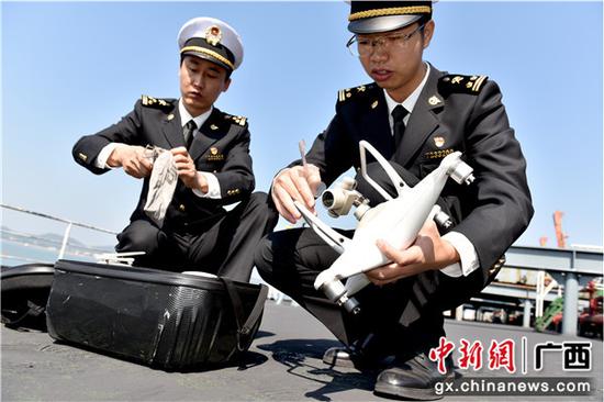 防城海关关员运正在安装用于入境船舶水尺计重的无人机。包拥军 摄 防城海关关员运正在安装用于入境船舶水尺计重的无人机。包拥军 摄
