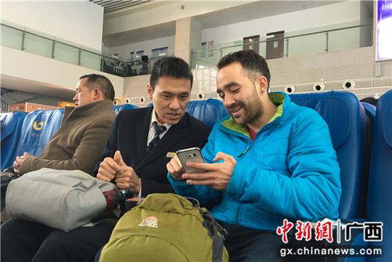闻斌向外籍旅客介绍网络订票的方法。 闻斌向外籍旅客介绍网络订票的方法。