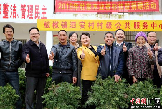 3月15日,在柳州融安县板榄镇泗安村2019年壮象木业香杉扶贫捐赠活动中,该县政协主席肖素青(左五)与政协常委叶新忠(右三)等与领取香杉苗的群众合影。陈国正 摄 3月15日,在柳州融安县板榄镇泗安村2019年壮象木业香杉扶贫捐赠活动中,该县政协主席肖素青(左五)与政协常委叶新忠(右三)等与领取香杉苗的群众合影。陈国正 摄