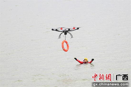 无人机给被困人员抛救生圈。雷阳 摄