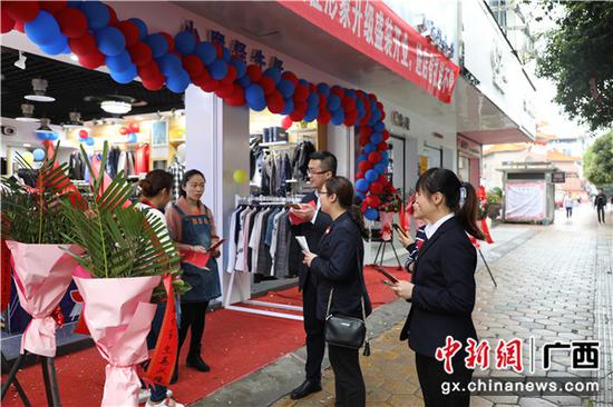邮储银行贺州市分行员工在向店铺工作人员介绍邮爱公益活动。 邮储银行贺州市分行员工在向店铺工作人员介绍邮爱公益活动。