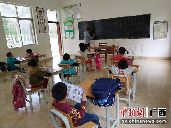 图为李均卓教孩子们拼音。 图为李均卓教孩子们拼音。