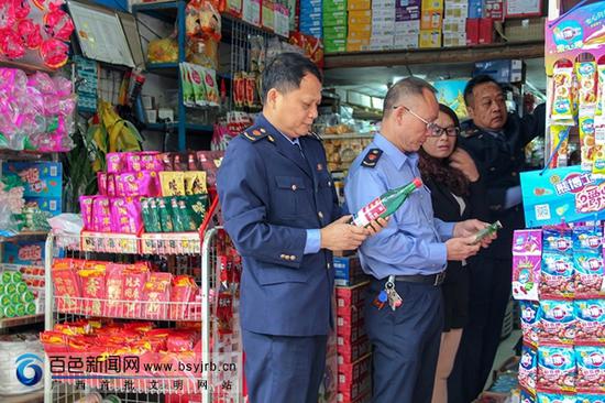 图为执法人员正在检查百货批货店的酒类专柜。 图为执法人员正在检查百货批货店的酒类专柜。