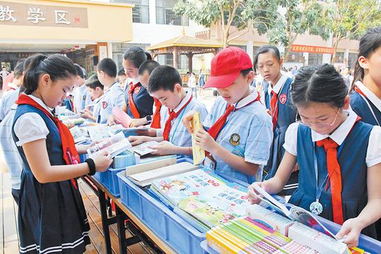 图为学生在世界图书日精品图书展览上阅读书籍。 图为学生在世界图书日精品图书展览上阅读书籍。