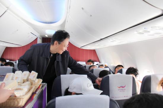 图为乌鲁木齐航空副董事长杨建平为乘客服务。 图为乌鲁木齐航空副董事长杨建平为乘客服务。