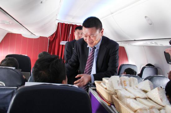 乌鲁木齐航空总裁吴浩与乘务员一起推出餐车为旅客提供餐饮服务。 乌鲁木齐航空总裁吴浩与乘务员一起推出餐车为旅客提供餐饮服务。