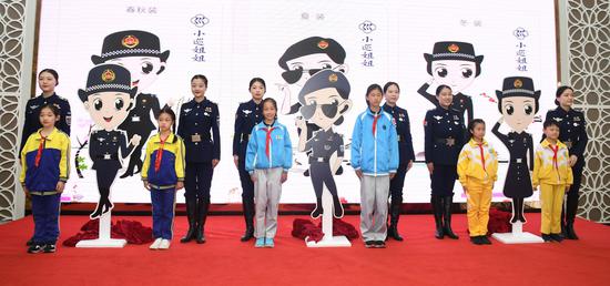 图为：队员与在杭小学学生代表共同揭晓卡通形象——“小巡姐姐”。王刚 摄