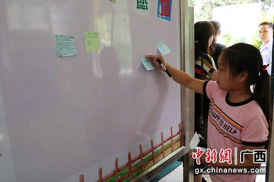 图为孩子们将心愿贴到“心愿墙”上。梁爽 摄 图为孩子们将心愿贴到“心愿墙”上。梁爽 摄