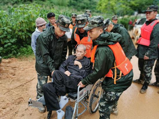 圖為武警官兵將幾名老人轉移到安全地帶。 圖為武警官兵將幾名老人轉移到安全地帶。