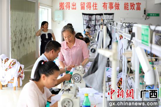易地扶贫搬迁群众在广西融安县老乡家园康欣易地扶贫搬迁点的微扶贫车间缝制服装。谭凯兴 摄 易地扶贫搬迁群众在广西融安县老乡家园康欣易地扶贫搬迁点的微扶贫车间缝制服装。谭凯兴 摄