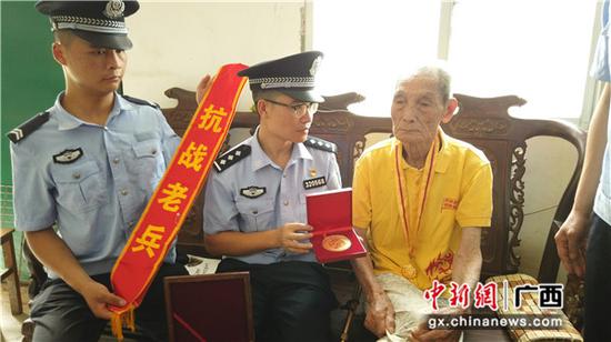 图为张德权老人正在向民警展示获赠的“中国人民抗日战争胜利70周年纪念章。 图为张德权老人正在向民警展示获赠的“中国人民抗日战争胜利70周年纪念章。