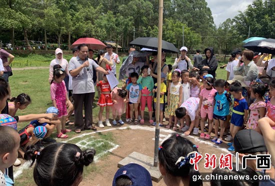 广西骆越文化研究会会长向小朋友讲解日照无影的特别现象。 广西骆越文化研究会会长向小朋友讲解日照无影的特别现象。