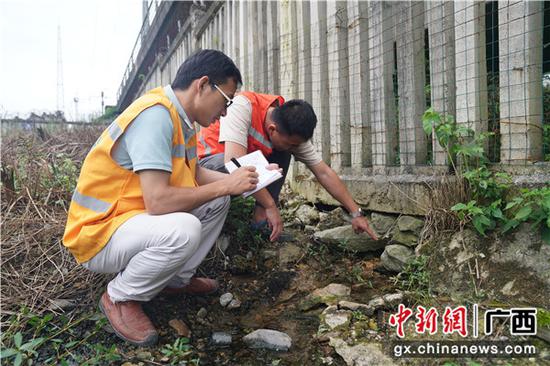 图为铁路职工正在记录水害冲空栅栏设备情况。 图为铁路职工正在记录水害冲空栅栏设备情况。