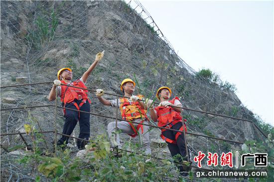图为铁路职工正在危石被动防护网上开展检查工作。 图为铁路职工正在危石被动防护网上开展检查工作。