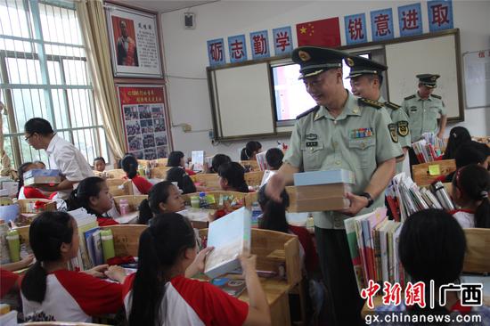 官兵们为红瑶女童班学生发放纪念品 。丁健 摄 官兵们为红瑶女童班学生发放纪念品 。丁健 摄