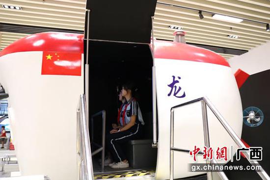 图为学生参观蛟龙号载人潜水器模拟舱。陈秋霞 摄 图为学生参观蛟龙号载人潜水器模拟舱。陈秋霞 摄