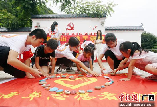 广西科技大学”三下乡”学生正在与孩子们拼石头彩绘画图。韦荣军 摄 广西科技大学”三下乡”学生正在与孩子们拼石头彩绘画图。韦荣军 摄