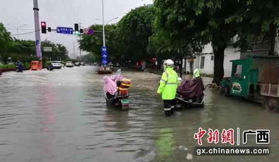 图为桂林市在积水深度较大的重要路段以及存在井盖冲开等隐患的路段安排专人值守。