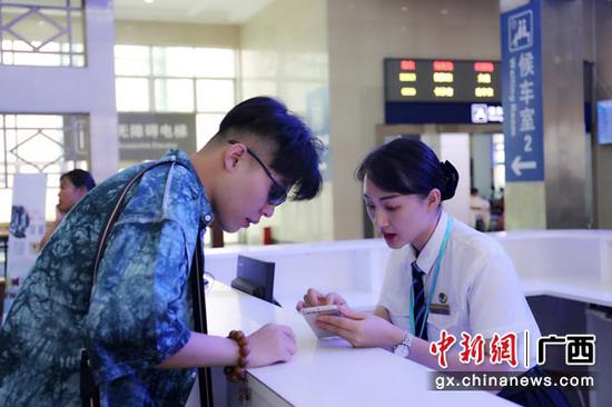 图为桂林火车站工作人员耐心解答旅客问讯。常国思 摄 图为桂林火车站工作人员耐心解答旅客问讯。常国思 摄