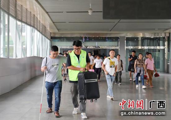 图为桂林火车站青年志愿者热情服务重点旅客。常国思 摄 图为桂林火车站青年志愿者热情服务重点旅客。常国思 摄