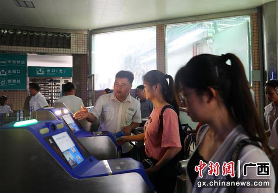 图为桂林火车站工作人员引导旅客“刷脸”进站。常国思 摄 图为桂林火车站工作人员引导旅客“刷脸”进站。常国思 摄
